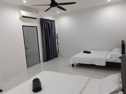 a bedroom with two beds and a ceiling fan at D'Sroja Home in Jerantut in Jerantut