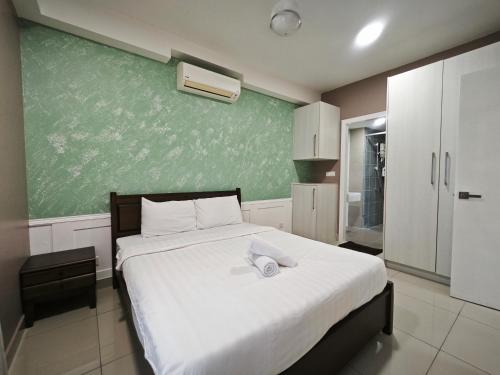 a bedroom with a large bed with a green wall at Solstice Cyberjaya by Idealhub in Cyberjaya