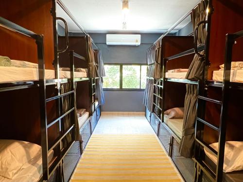 a room filled with bunk beds with a hallway at El biógrafo in Bangkok