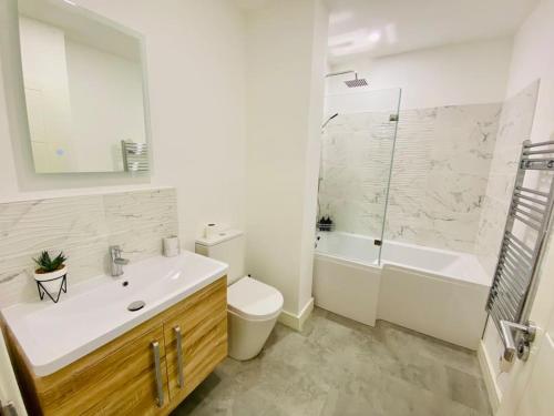a bathroom with a sink and a toilet and a shower at Ten - Central Apartment - Contractors Professionals in Gloucester