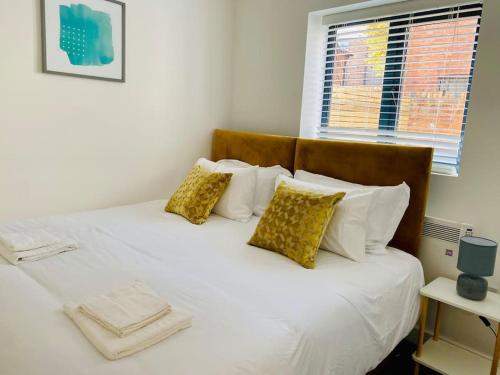 a bed with white sheets and pillows and a window at Ten - Central Apartment - Contractors Professionals in Gloucester