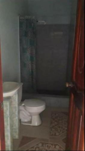a bathroom with a white toilet and a sink at Waica House in Bahía de Caráquez
