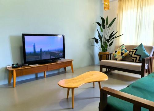 un soggiorno con TV a schermo piatto su un tavolo di "Cloth Art Homestay" walk to Pahlawan & Jonker by Shine Stay a Malacca