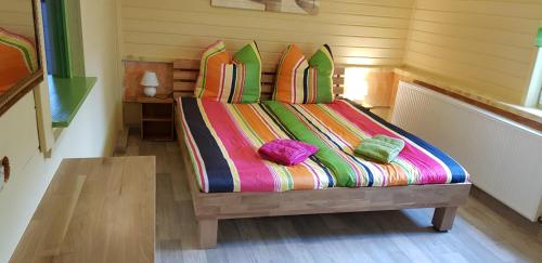 1 dormitorio con 1 cama con sábanas y almohadas coloridas en Ferienwohnung an der Kurpromrnade, en Bad Schandau
