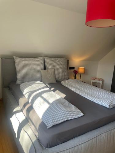 a large bed with pillows on it in a room at Allgäu Cottage - traumhafter Blick in die Schweizer Berge in Weiler-Simmerberg