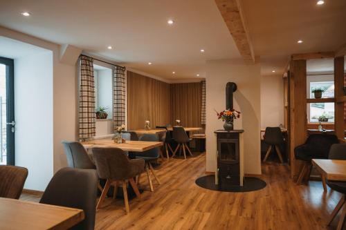 a restaurant with tables and chairs and a wood stove at Boutique Hotel Haus Marie in Gerabronn