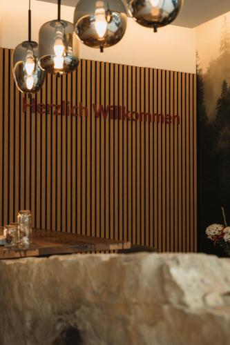 a table in a restaurant with a sign on the wall at Boutique Hotel Haus Marie in Gerabronn