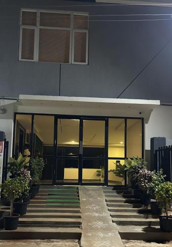 a building with large glass doors and potted plants at Seasons Stay in Vijayawāda
