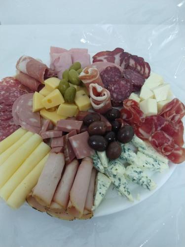 a plate of different types of meats and cheese at HOSTAL DEL SOL in Manuel Elordi
