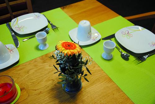 a table with a vase with a flower on it at Pension Augenblick in Greifswald