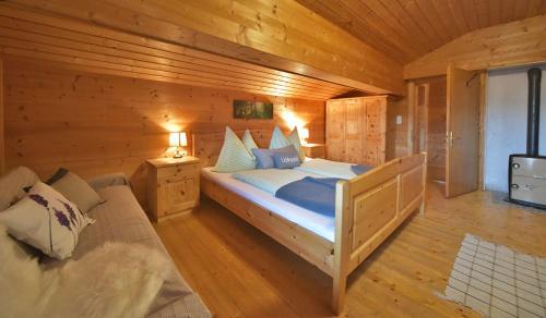 a bedroom with a bed in a wooden cabin at RANGERSDORFER HÜTTE in Witschdorf