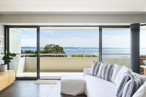 a living room with a couch and a view of the ocean at Sundance in Nelson Bay