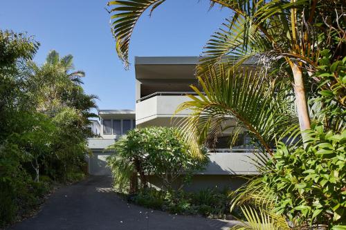 a building with a palm tree next to a driveway at Sundance in Nelson Bay