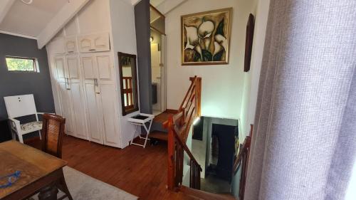 una sala de estar con escalera y una habitación con mesa y sillas. en Gadute Haven, en Pretoria