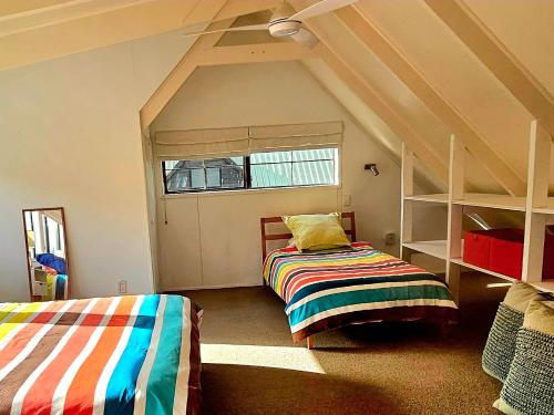 1 dormitorio con 2 literas y ventana en Forest Waters Bungalow en Haruru