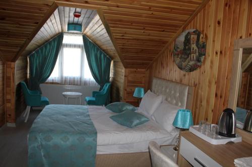 1 dormitorio con 1 cama en una habitación con paredes de madera en ADRİA ALADAĞ-GOLCÜK, en Seben