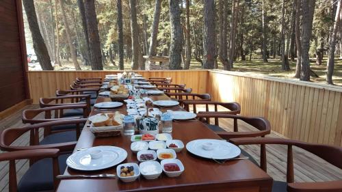 una mesa larga con sillas, platos y comida. en ADRİA ALADAĞ-GOLCÜK, en Seben