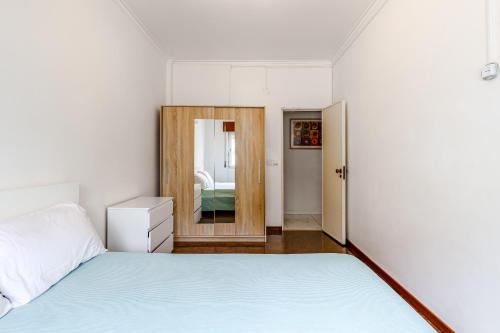 - une chambre avec un lit et un miroir dans l'établissement Moreira, à Amora