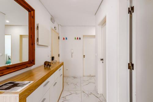 eine Küche mit weißen Wänden, einem Spiegel und einer Theke in der Unterkunft Moreira in Amora