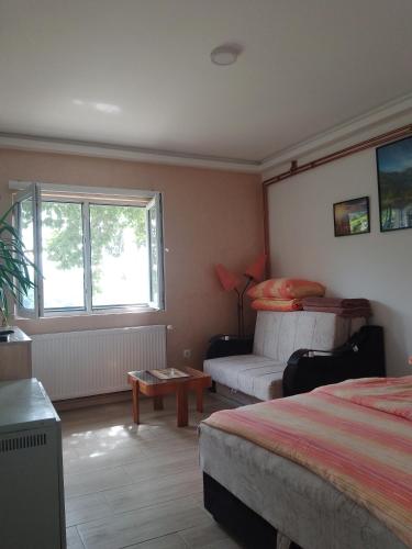 a bedroom with two beds and a window and a table at Uzicki-konaci in Užice