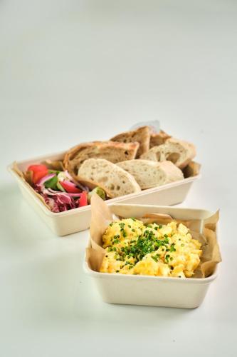 three containers of food with bread and eggs at Boutique Residence Gdańsk in Gdańsk
