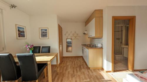 a kitchen and dining room with a wooden table and chairs at Imhof Alpine B&B Apartments in Bettmeralp