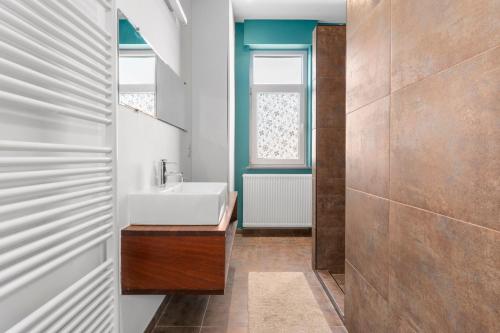 ein Bad mit einem weißen Waschbecken und einem Fenster in der Unterkunft Gezellige villa aan zee met ruim terras voor 6p in De Panne