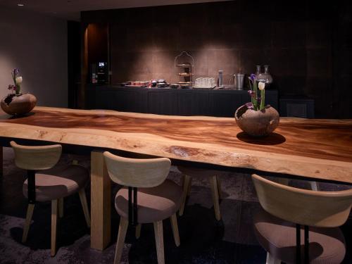 a wooden table with chairs and vases on top of it at Hotel The Celestine Kyoto Gion in Kyoto
