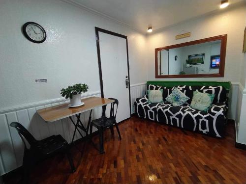 a room with a bed and a table and a mirror at Green Valley Condo with View in Baguio