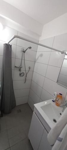 a white bathroom with a shower and a sink at אירוח סמוך לים התיכון in Haifa