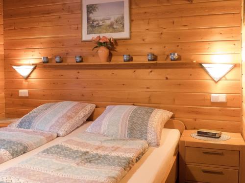 twee bedden in een kamer met houten wanden bij Ferienhaus Nr 15, Typ A, Feriendorf Jägerpark, Bayerischer Wald in Viechtach