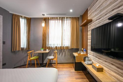 a living room with a table and a large television at 綺樂文旅 康定館 Le Room Hotel Kangding in Taipei