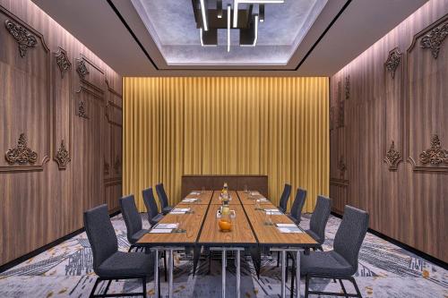 a conference room with a long wooden table and chairs at Renaissance Kuala Lumpur Hotel & Convention Centre in Kuala Lumpur