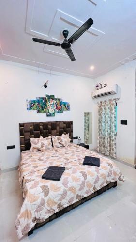 a bedroom with a large bed with a ceiling fan at Nirmal sadan Homestay in Kāman