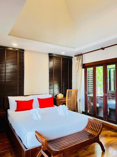 a bedroom with a large white bed with red pillows at Yotaka Boutique Hotel Bangkok in Bangkok