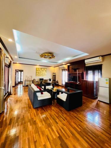 a large living room with couches and a kitchen at Yotaka Boutique Hotel Bangkok in Bangkok