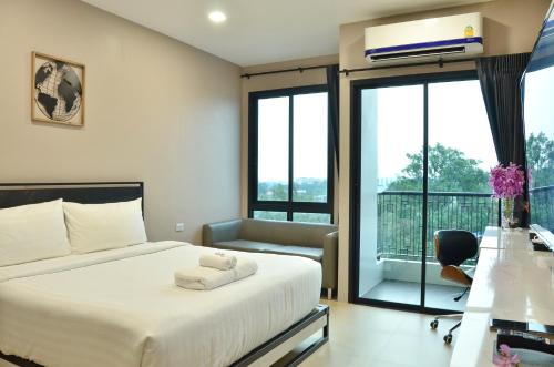 um quarto de hotel com uma cama e uma varanda em NORN Rimkhlong Bangkok นอนริมคลอง em Bangkok Noi