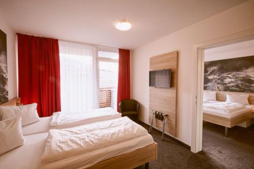 a hotel room with two beds and a window at Hotel Planai by Alpeffect Hotels in Schladming