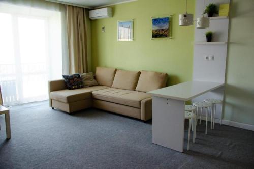 uma sala de estar com um sofá e uma mesa em Tumar Apart Hotel em Karaganda