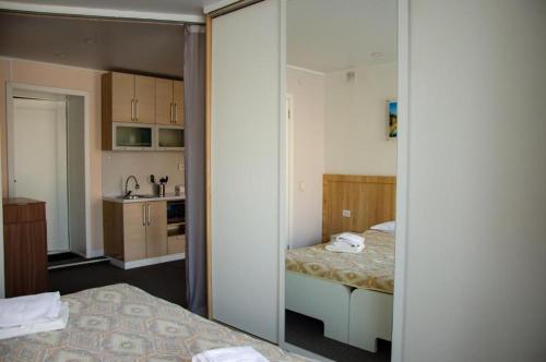 um pequeno quarto com 2 camas e uma cozinha em Tumar Apart Hotel em Karaganda