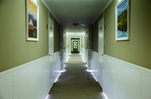 an empty hallway with a long corridor with paintings on the walls at Tumar Apart Hotel in Karagandy
