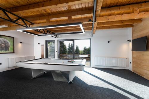a pool table in a living room with a ceiling at forest angel rg in Ravna Gora