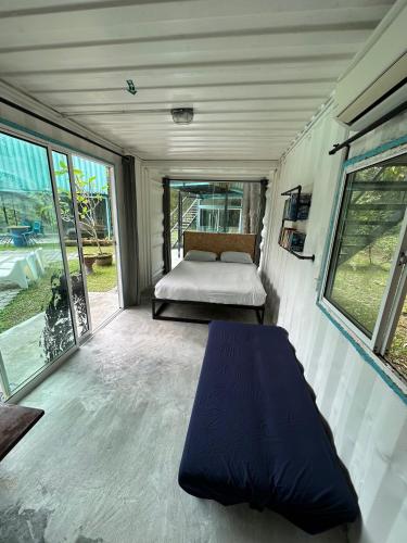 a bedroom with a bed in a tiny house at Sarang by the brook in Kuala Kubu Baharu