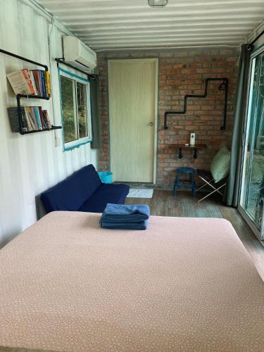 a living room with a blue couch and a brick wall at Sarang by the brook in Kuala Kubu Baharu