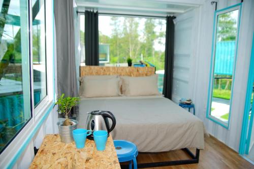 1 dormitorio con 1 cama con tazas azules sobre una mesa en Sarang by the brook en Kuala Kubu Baharu
