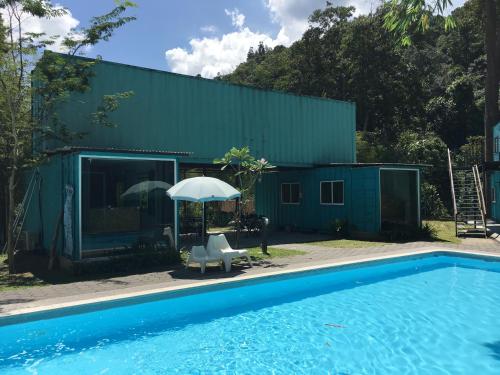 a house with a swimming pool and an umbrella at Sarang by the brook in Kuala Kubu Baharu