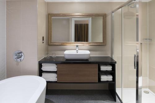 a bathroom with a sink and a mirror at Renaissance London Heathrow Hotel in Hillingdon