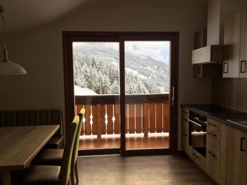 a kitchen with a sliding glass door with a mountain view at Mönchsberghof in Kleinarl