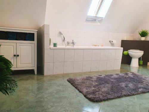 een badkamer met een bad, een toilet en een tapijt bij Rittergut Dornreichenbach 