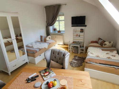 een kleine kamer met 2 bedden en een woonkamer bij Rittergut Dornreichenbach 
